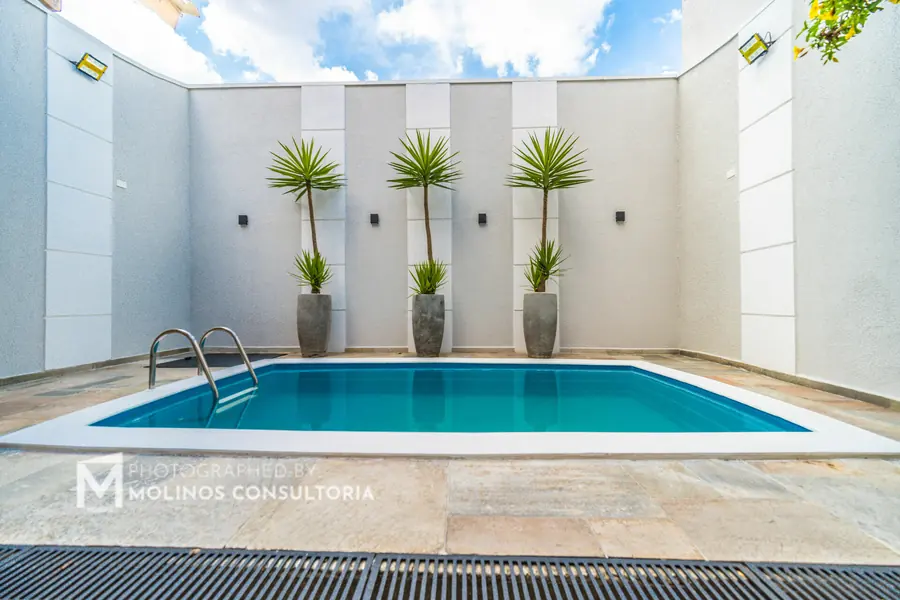 Piscina com muro em placas e vasos